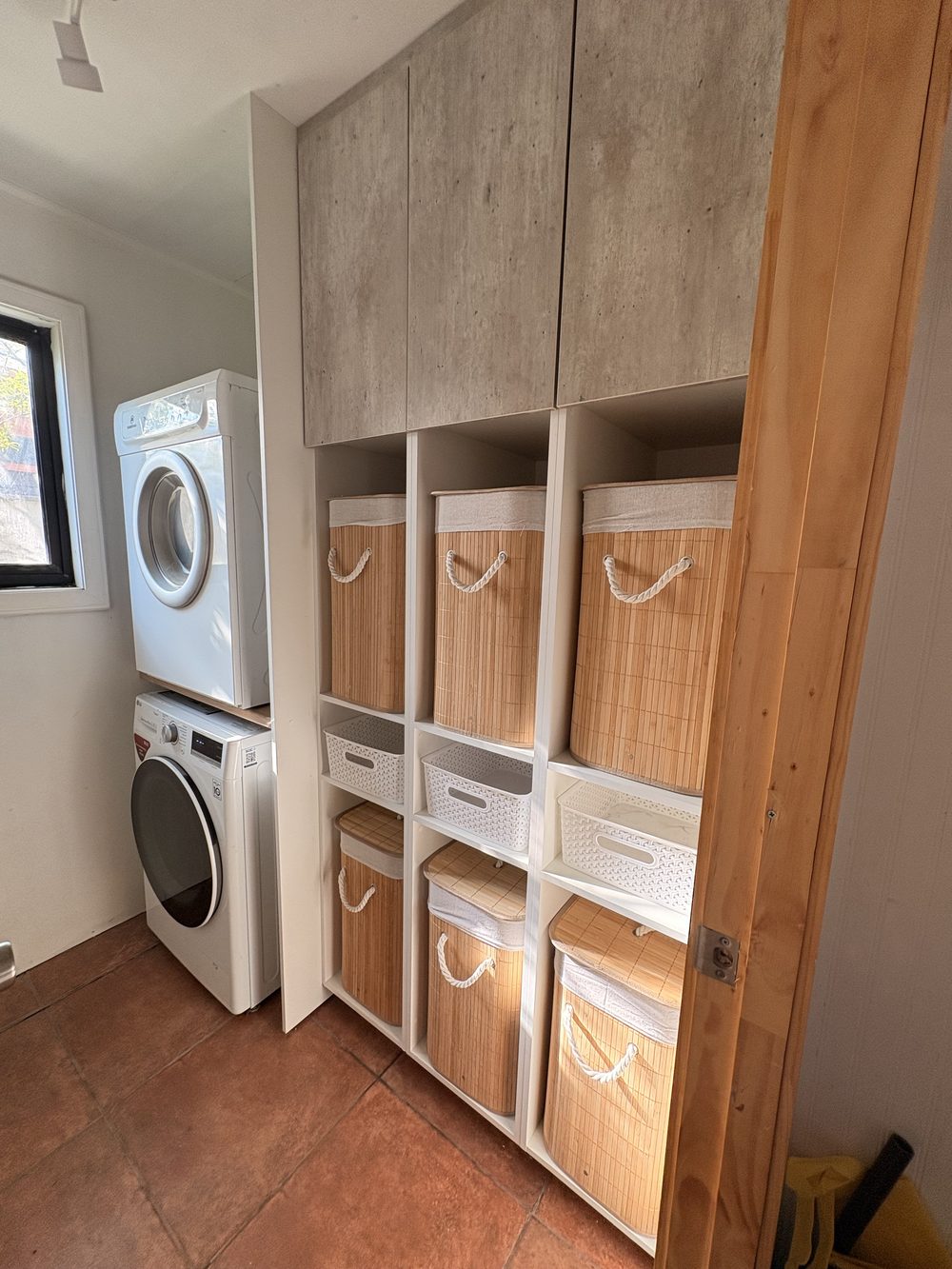 Mueble de lavandería con repisas de madera y espacio para canastos